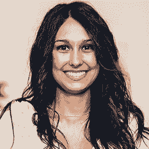 A woman with long, wavy dark hair smiles at the camera. She is wearing a light-colored top against a neutral background, representing the spirit of Brain Injury Support and the mission of NBIS.