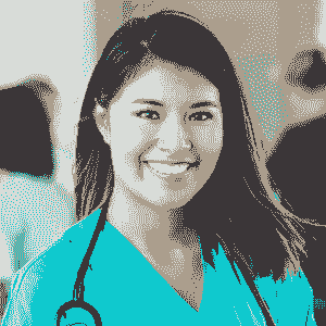 A young woman wearing teal scrubs and a stethoscope smiles at the camera, suggesting she is a healthcare professional involved in Brain Injury Education with the Nanaimo Brain Injury Society. The background is softly blurred, showing indistinct people.
